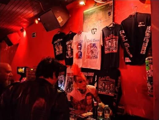 Pared de camisetas y merch del Wurlitzer Ballroom bajo luz roja